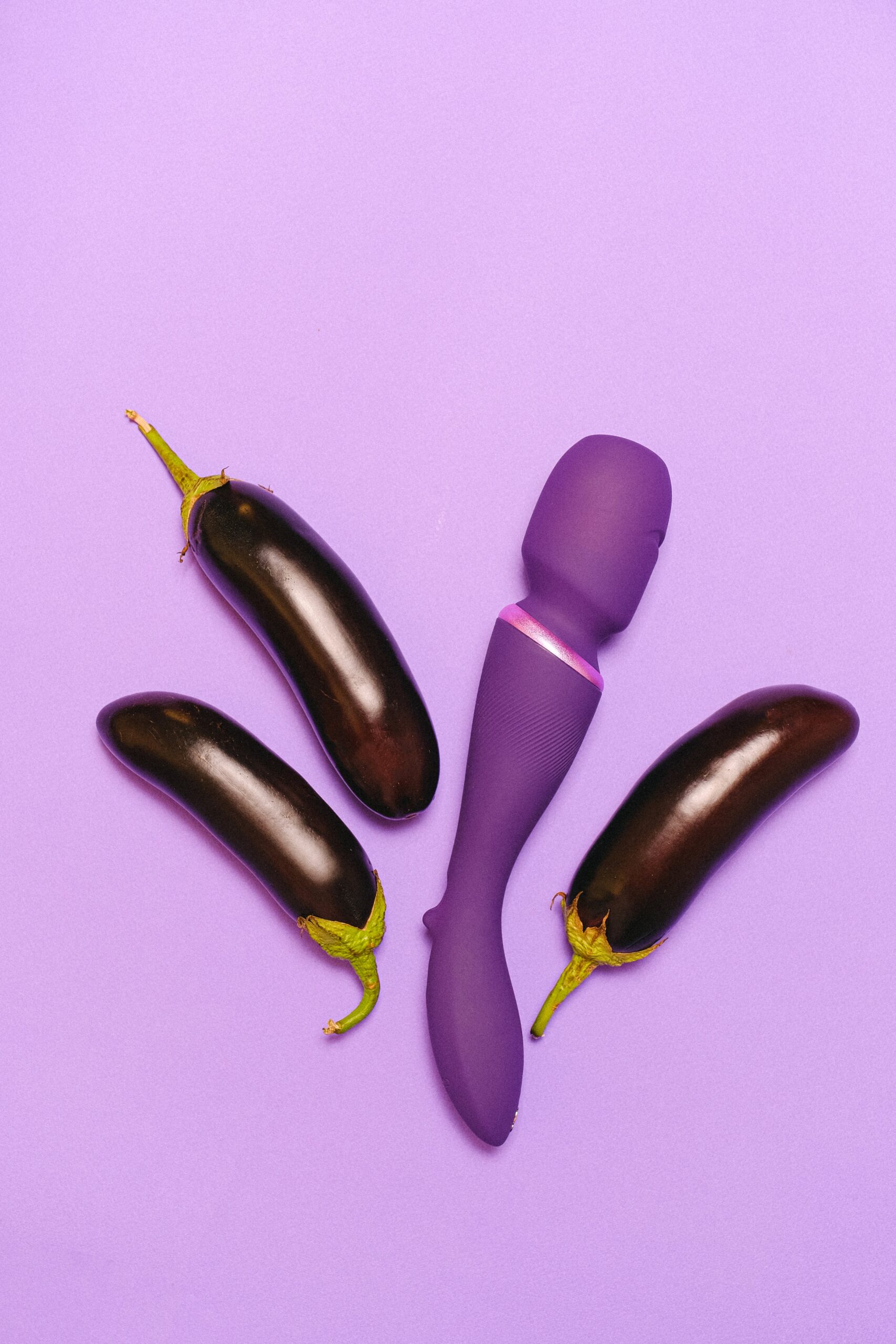 A photo of a purple sex toy against a purple background, next to 3 eggplants. Used as the promotional image for a post by GETSOME Podcast on whether or not it's normal to not like casual sex and hooking up.
