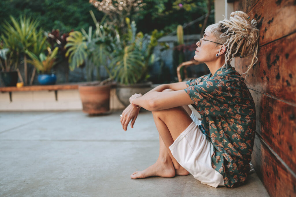 Person sitting on the ground in thoughtful posture, facing away from the camera—used to reflect emotional disconnection after feeling numb during sex.